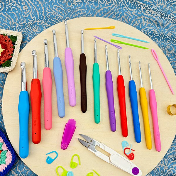 Set of 21 ergonomic crochet hooks in various sizes and colors, with accessories like stitch markers and a yarn needle.