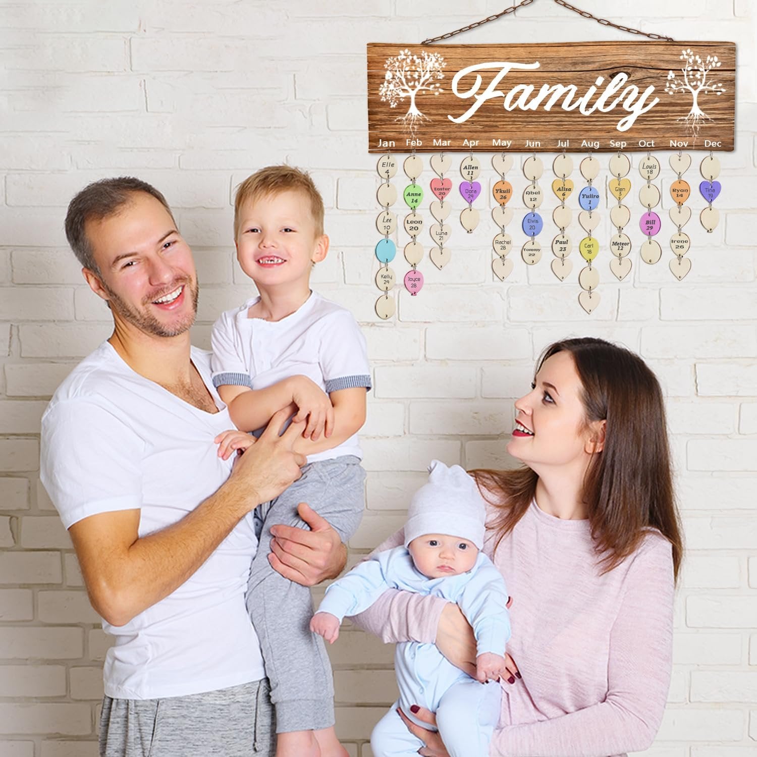 Family of four posing in front of a wooden family calendar with heart-shaped tags for birthdays and anniversaries.
