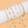 Several pearl and gold bead bracelets arranged on a white cylinder, with loose beads scattered around.