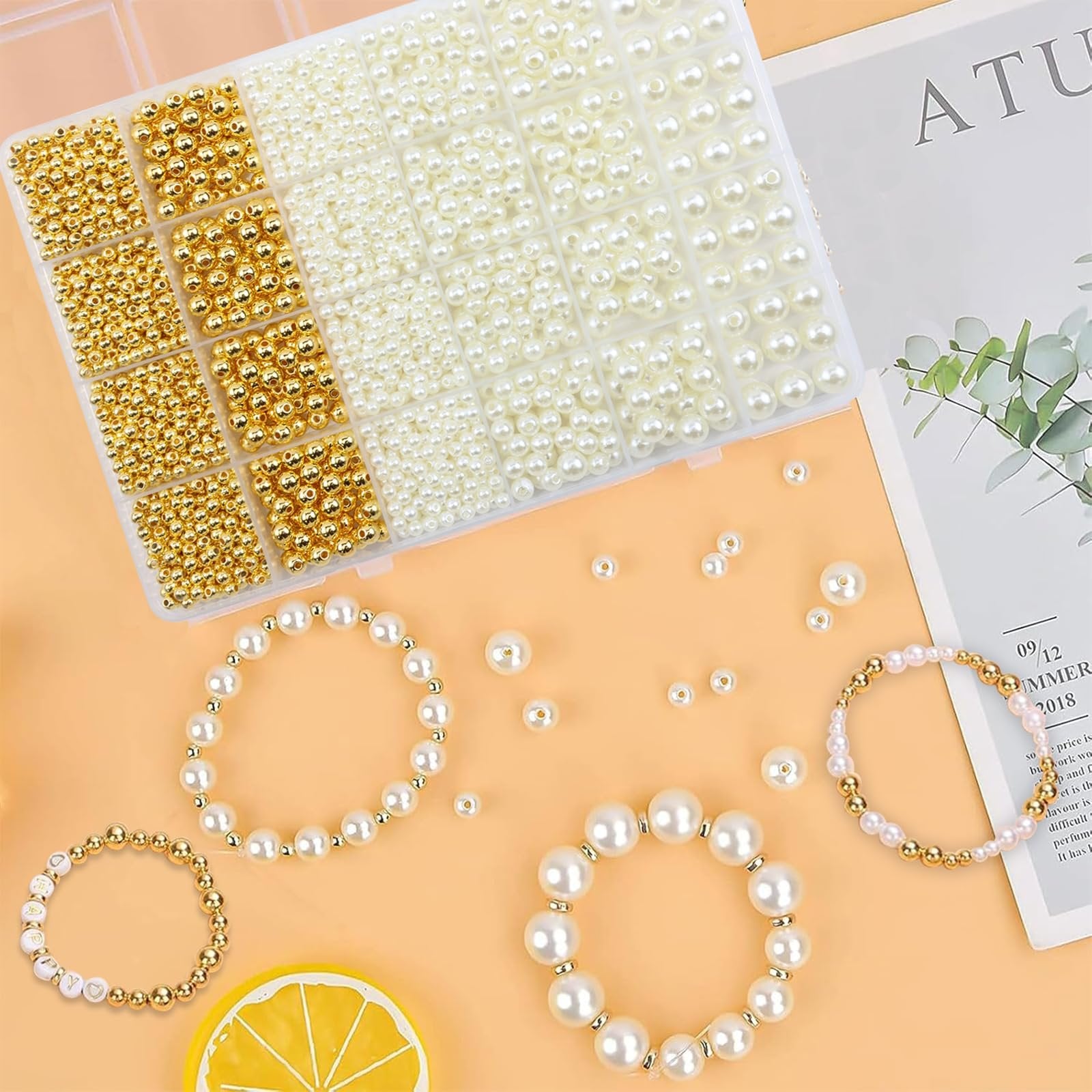 Bracelet bead kit with gold and ivory pearl beads, organized in a clear plastic box, with finished bracelets and a lemon slice.