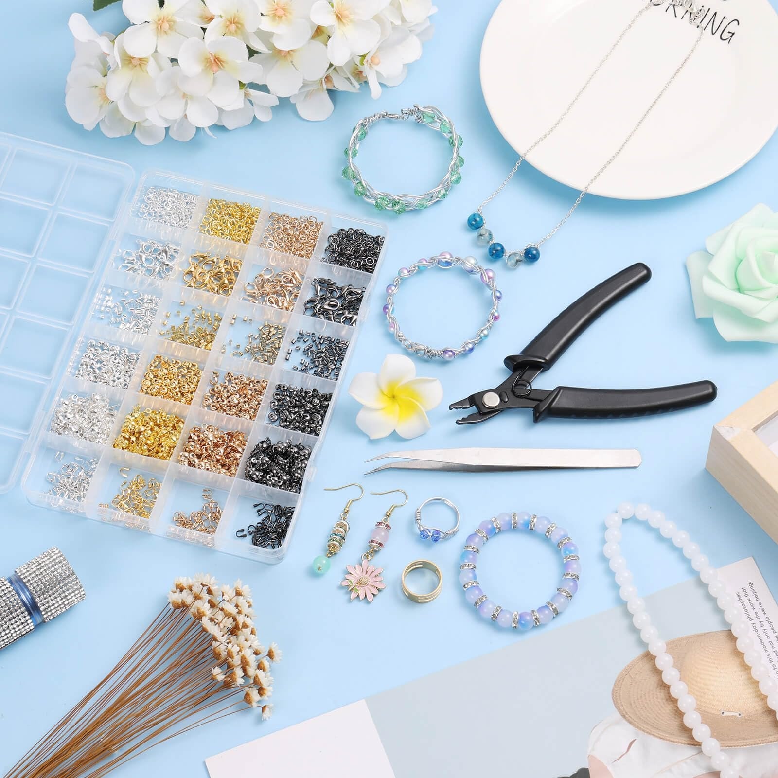 Jewelry making kit with pliers, tweezers, and assorted beads, clasps, and findings in a divided organizer.