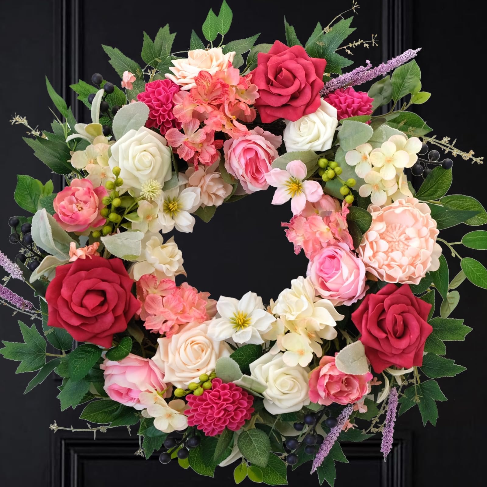 Front door wreath with red, pink, and white roses, dahlias, and greenery against a black door.