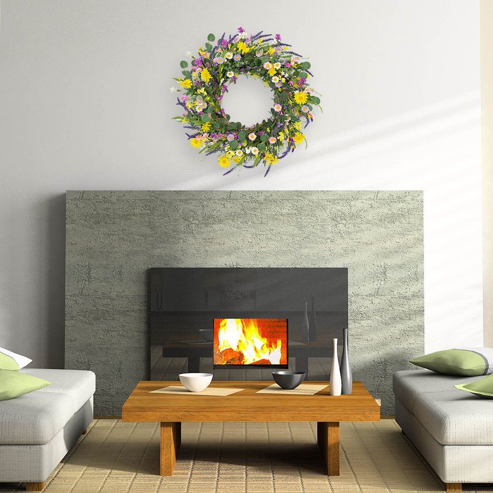 Artificial spring wreath with daisies, lavender, jasmine, and wildflowers on a grapevine base, displayed above a fireplace.