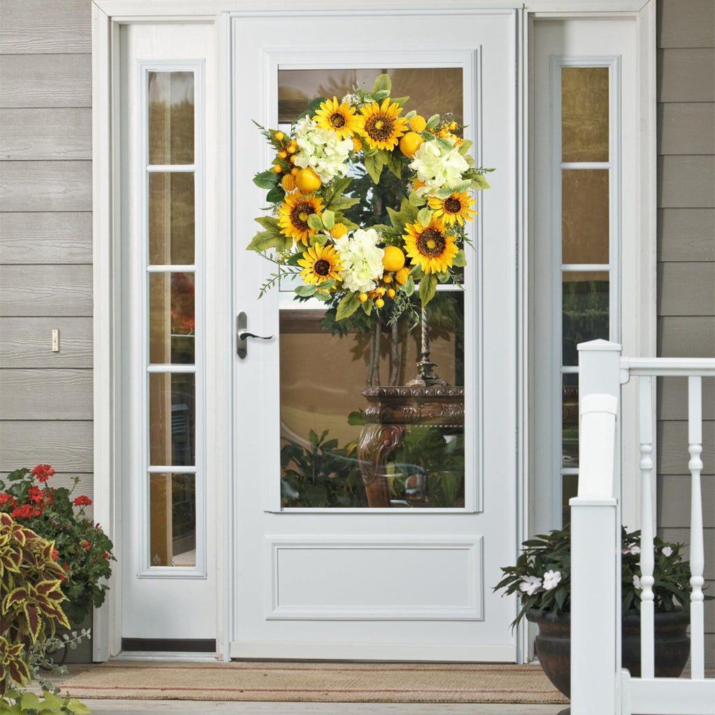 22-inch artificial sunflower wreath with hydrangeas, lemons, and berries hanging on a white front door.