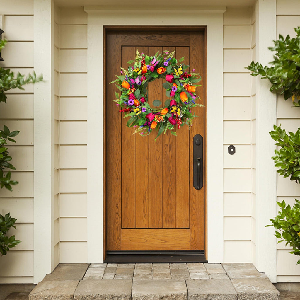 Front door decorated with a colorful artificial tulip wreath featuring silk greenery and butterflies.