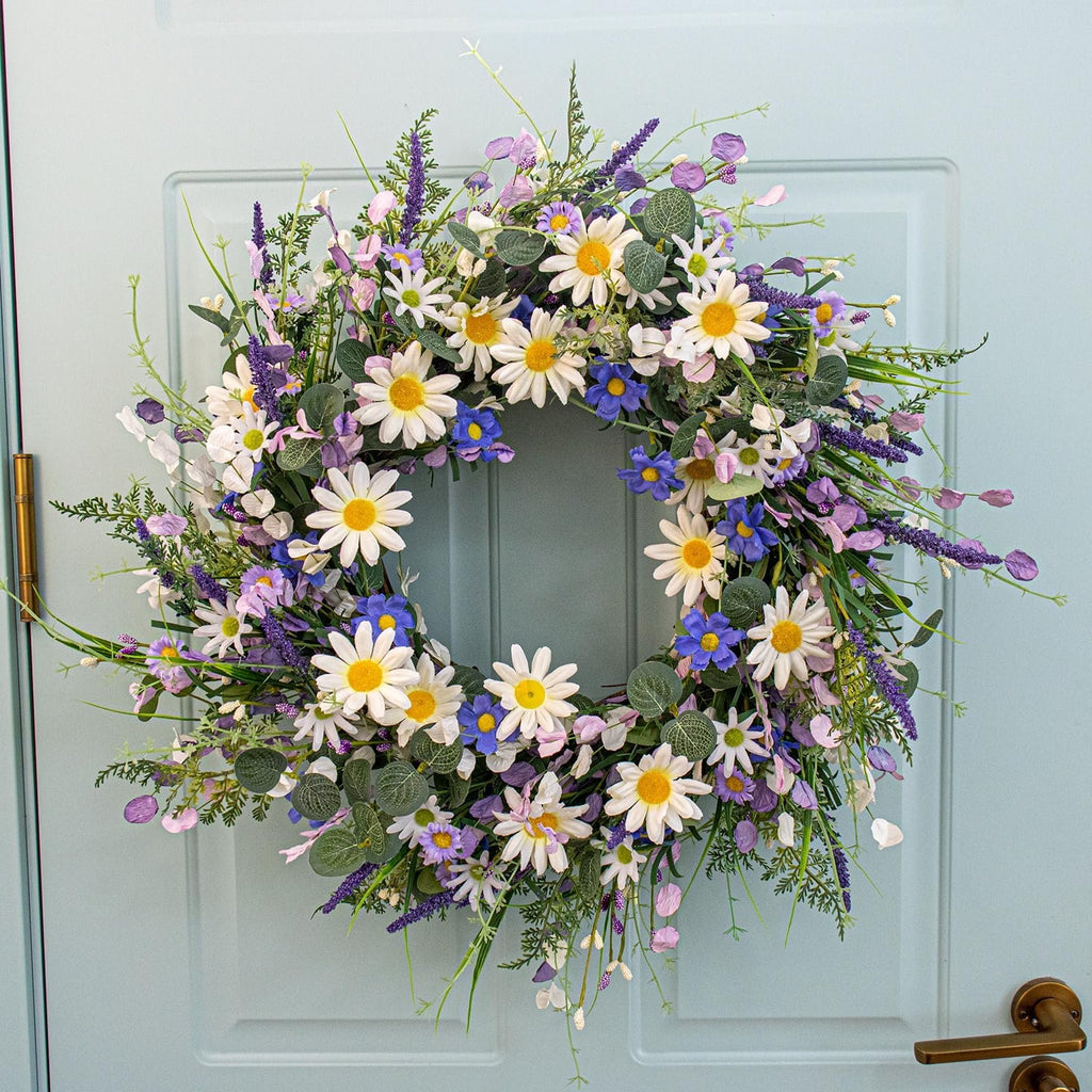 22-inch blue summer wreath with daisies, lavender, wildflowers, and eucalyptus hanging on a light blue door.