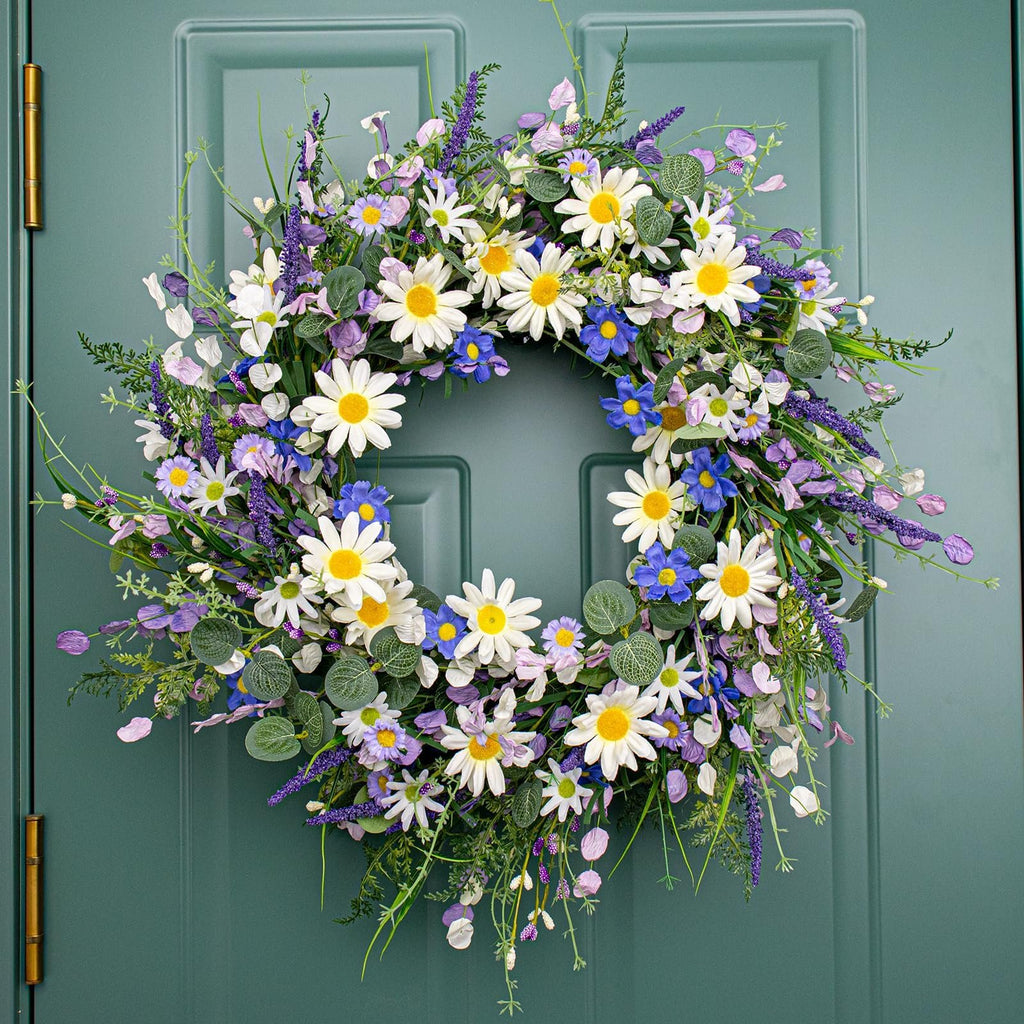 Front view of a blue summer wreath with daisies, lavender, wildflowers, and eucalyptus hanging on a teal door.