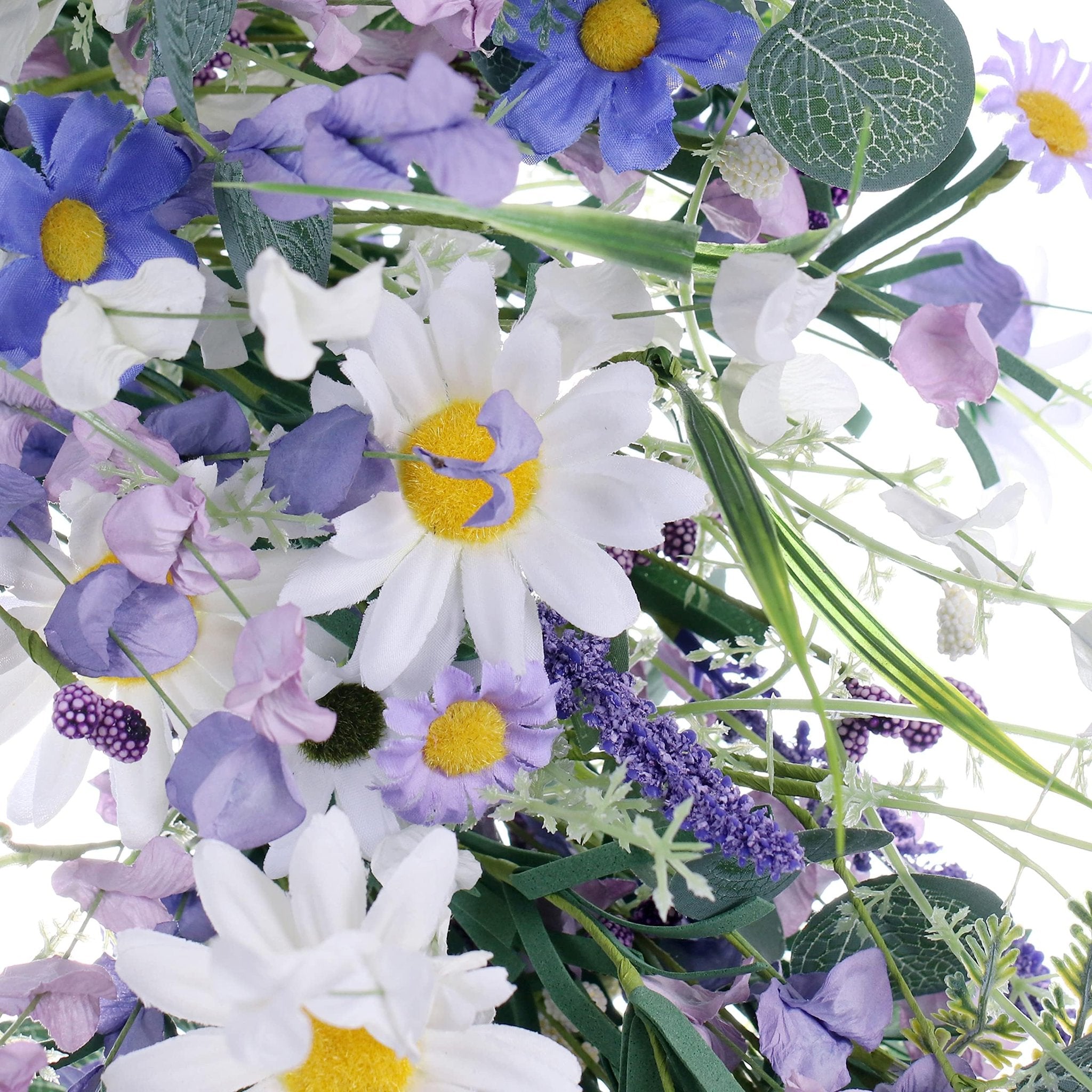 Close-up of a blue and white artificial summer wreath with daisies, lavender, and eucalyptus leaves.