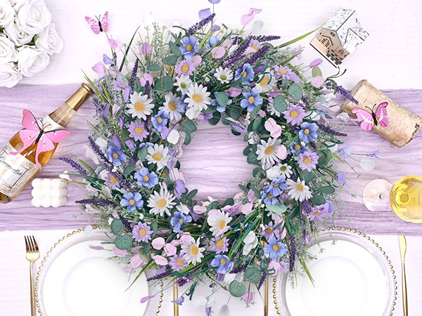 Spring daisy and lavender wreath with eucalyptus on a table setting with champagne bottle and plates