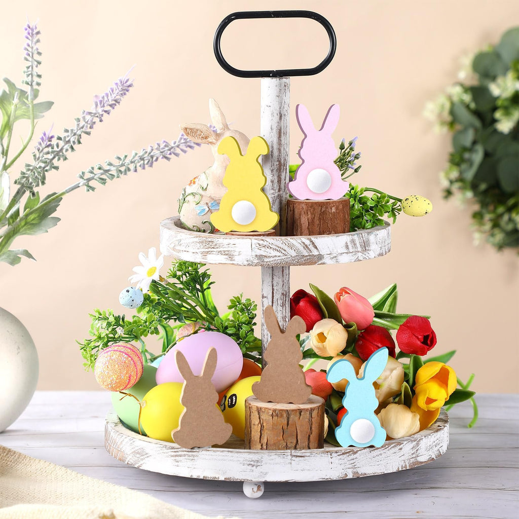 Tiered tray decorated for Easter with wood bunny cutouts, faux eggs, tulips, and greenery.