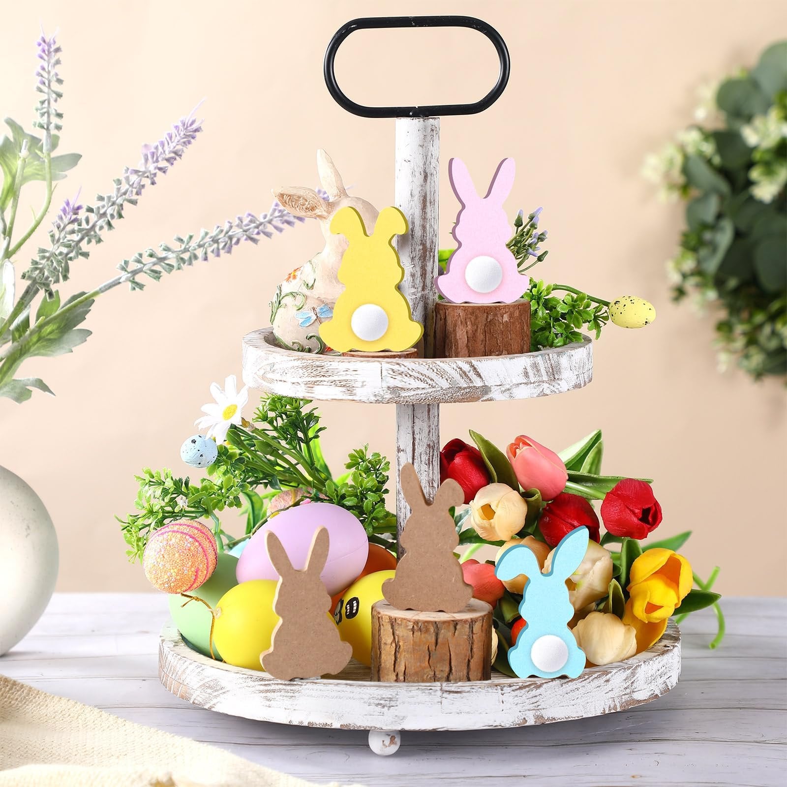 Tiered tray decorated for Easter with wood bunny cutouts, faux eggs, tulips, and greenery.