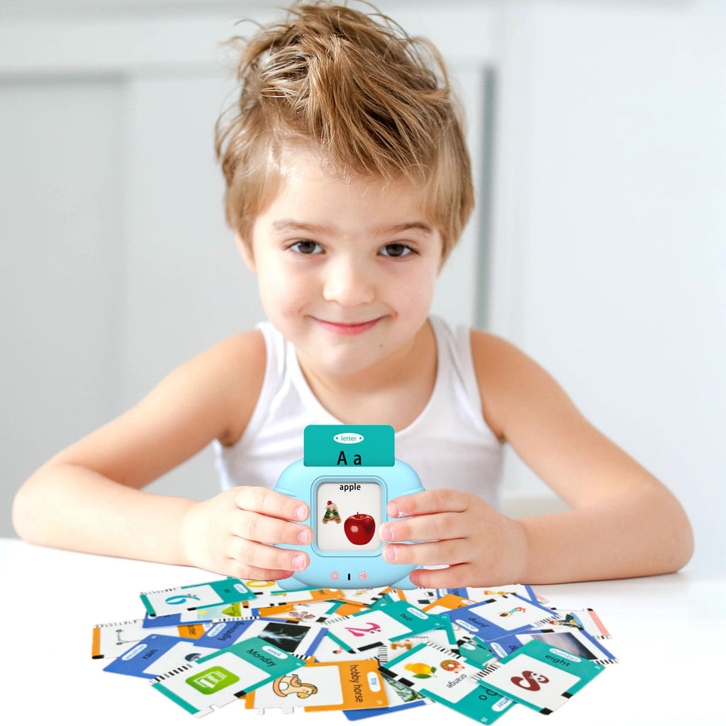 Child holding a blue learning device with flashcards spread around, showing letter A and apple.