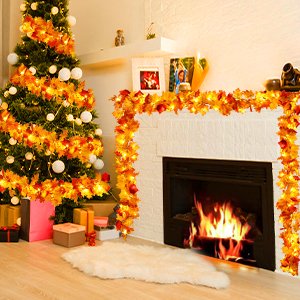 Fall-themed Christmas tree and fireplace decorated with illuminated maple leaf garlands and string lights.