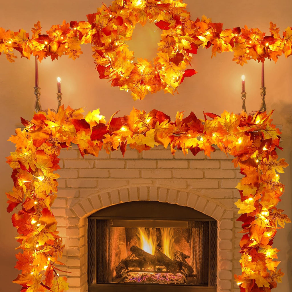 Faux maple leaf garland with warm LED lights draped around a fireplace and on a mantelpiece.