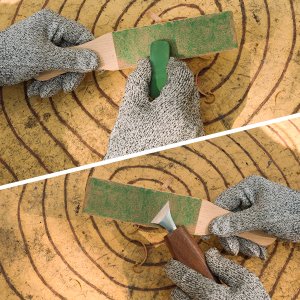 Hands wearing grey protective gloves sharpening wood carving tools on a green strop