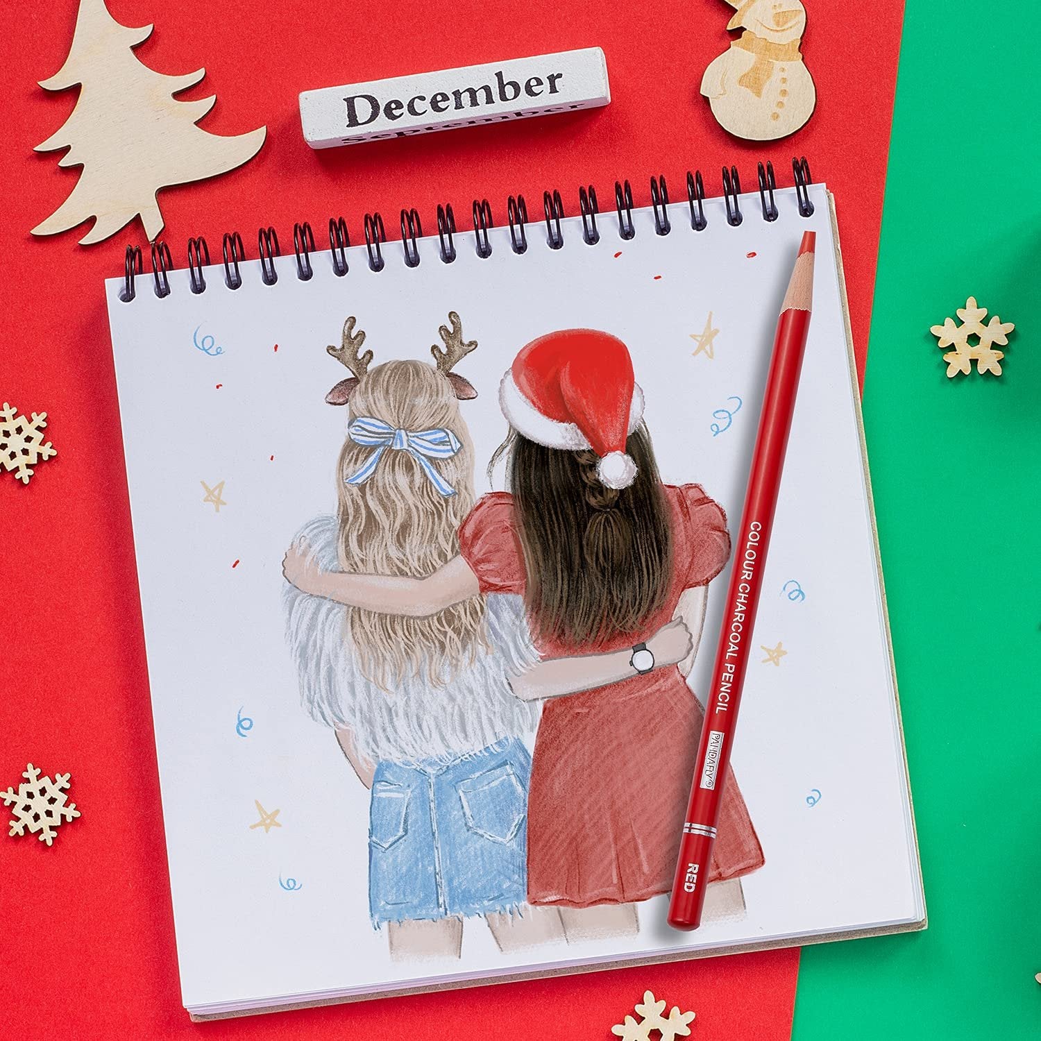 Two girls hugging, one wearing a Santa hat, drawn on a sketchbook page with a red charcoal pencil.