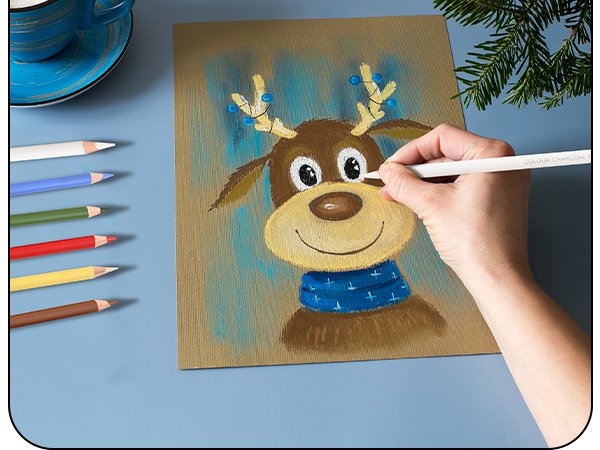 Hand drawing a reindeer portrait with pastel charcoal pencils on brown paper, with pencils and coffee cup nearby.