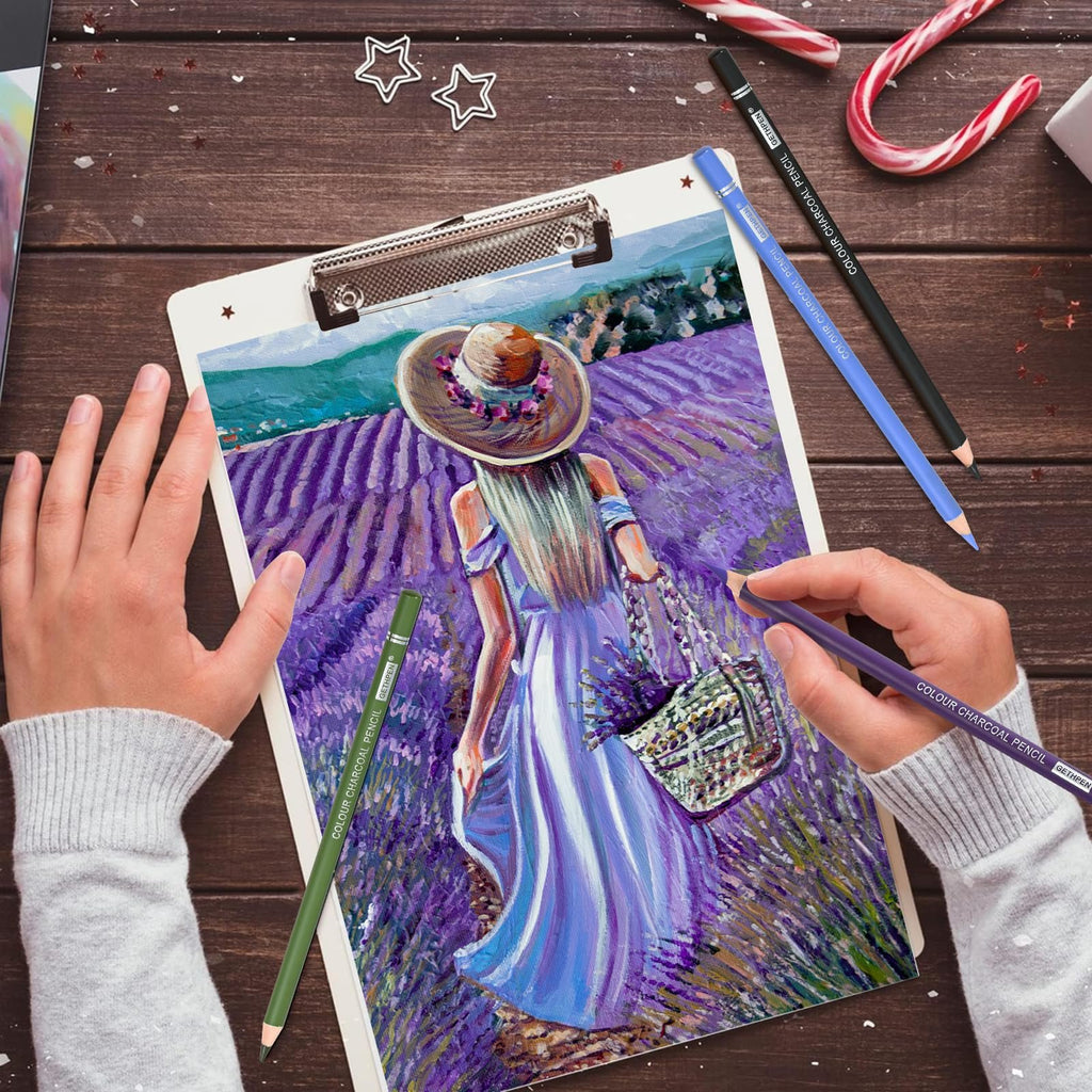 Hands holding charcoal pencils drawing a lavender field scene on a clipboard