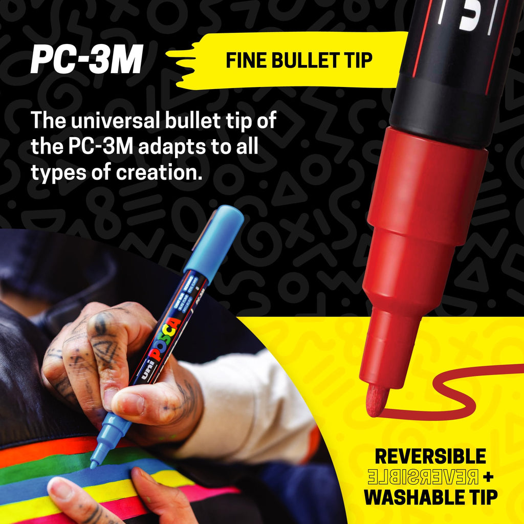 Close-up of a hand using a blue fine bullet tip paint marker to draw on a surface with colorful stripes. A red marker tip is also visible.
