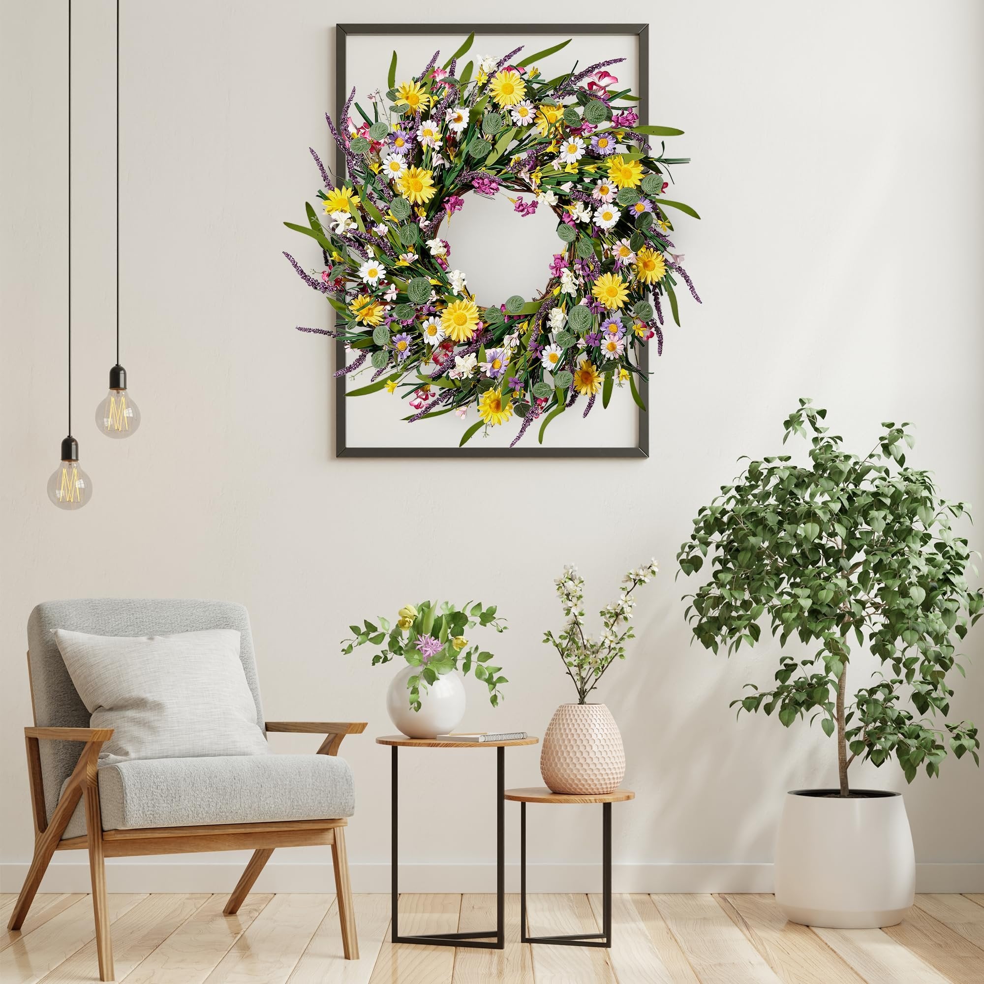 Artificial daisy and lavender wildflower wreath hanging on a wall above a chair and side tables.