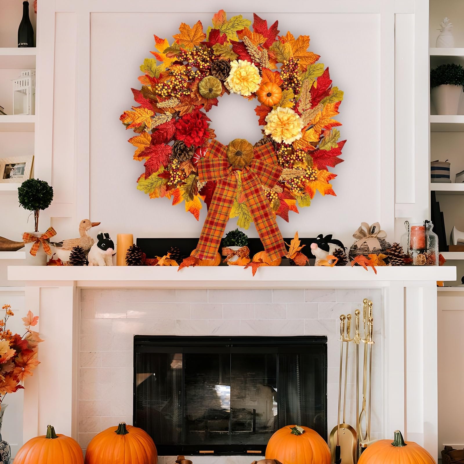 Fall wreath with pumpkins, berries, dahlias, and plaid bow hanging above a fireplace mantel decorated with pumpkins and figurines.