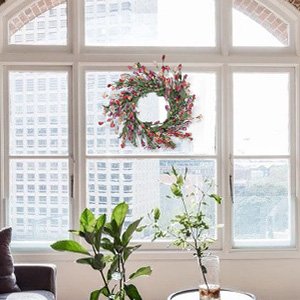 24 inch handmade wreath with EVA leaves and paper flowers hanging on a window