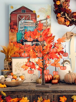 Lighted maple leaves tree with pumpkin ornaments and fall decor, featuring a barn and truck painting in the background.