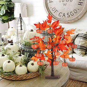 Lighted maple leaves tree with 24 LEDs and 12 wood pumpkin ornaments, set on a table with pumpkins and fall decor.
