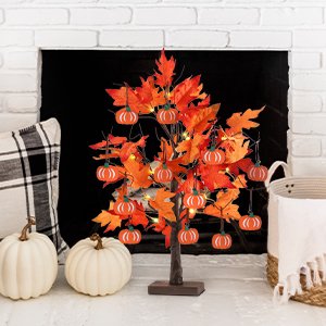 Lighted maple leaves tree with 24 LEDs and 12 wood pumpkin ornaments, displayed on a mantelpiece with pumpkins and a basket.