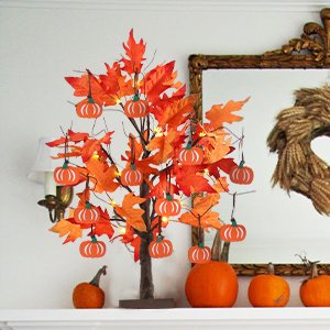 24-inch lighted maple leaves tree with 12 wood pumpkin ornaments on a mantelpiece