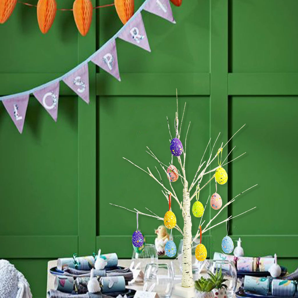 White birch Easter tree with colorful glitter eggs and warm white LED lights, set on a table with festive decorations.