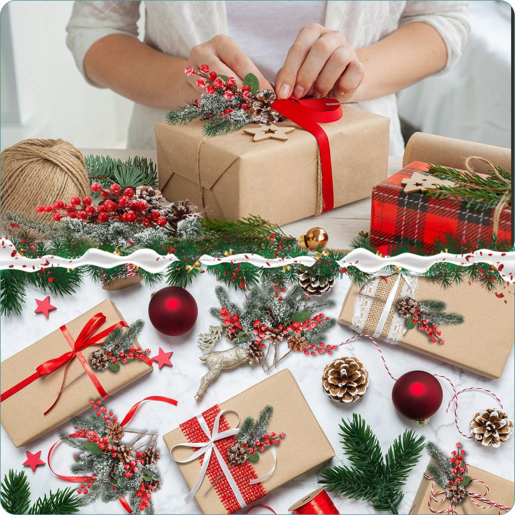 Hands decorating a gift box with artificial Christmas berry and pine sprigs, surrounded by wrapped gifts and ornaments.
