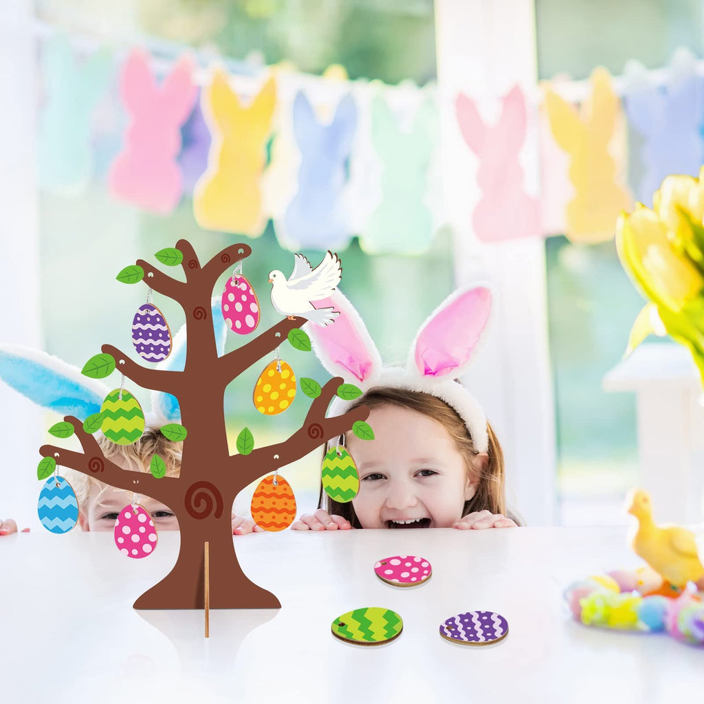 Wooden Easter egg tree craft kit with colorful egg cutouts and a dove decoration, with children wearing bunny ears in the background.