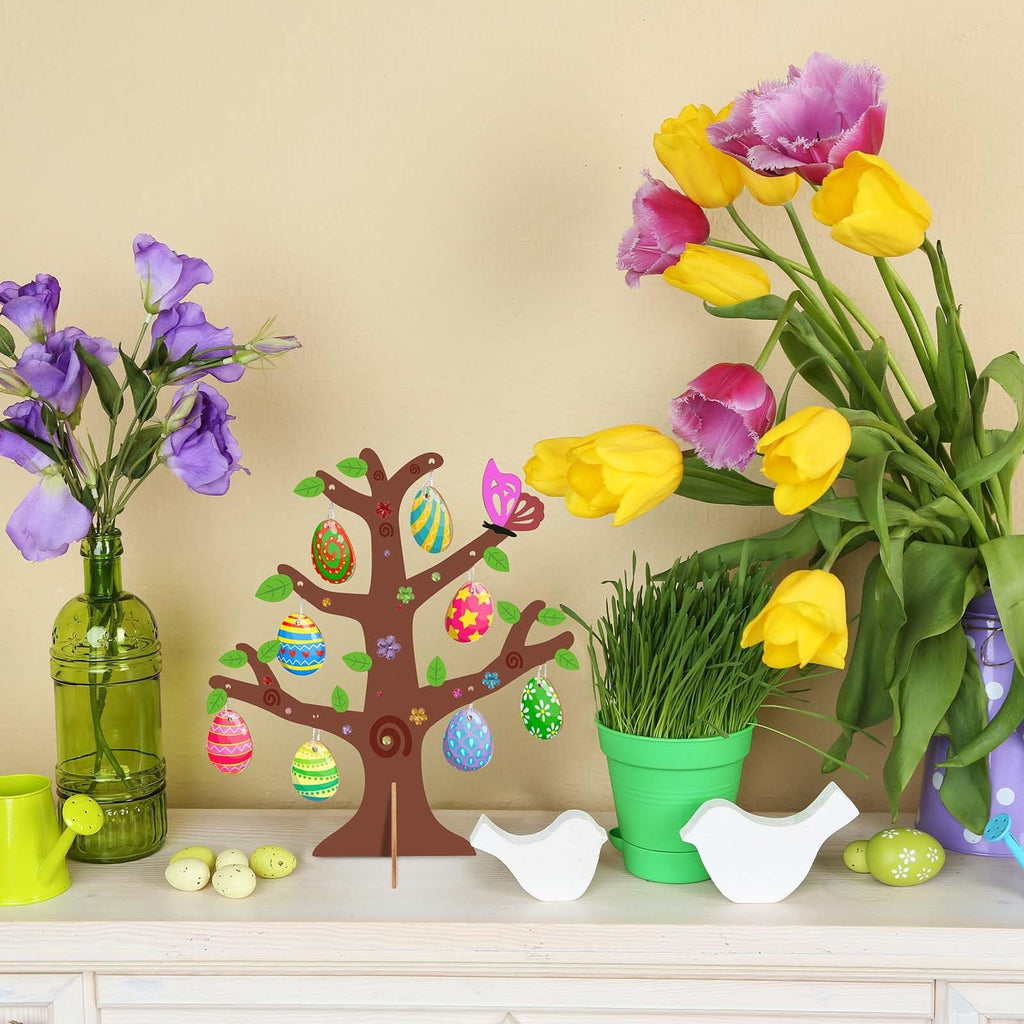 Wooden Easter egg tree craft kit with decorated eggs hanging from branches, set on a shelf with flowers and decorative birds.