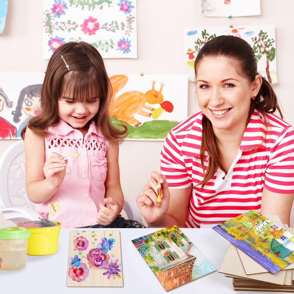 Woman and child painting on wood sheets at a table with artwork on the wall