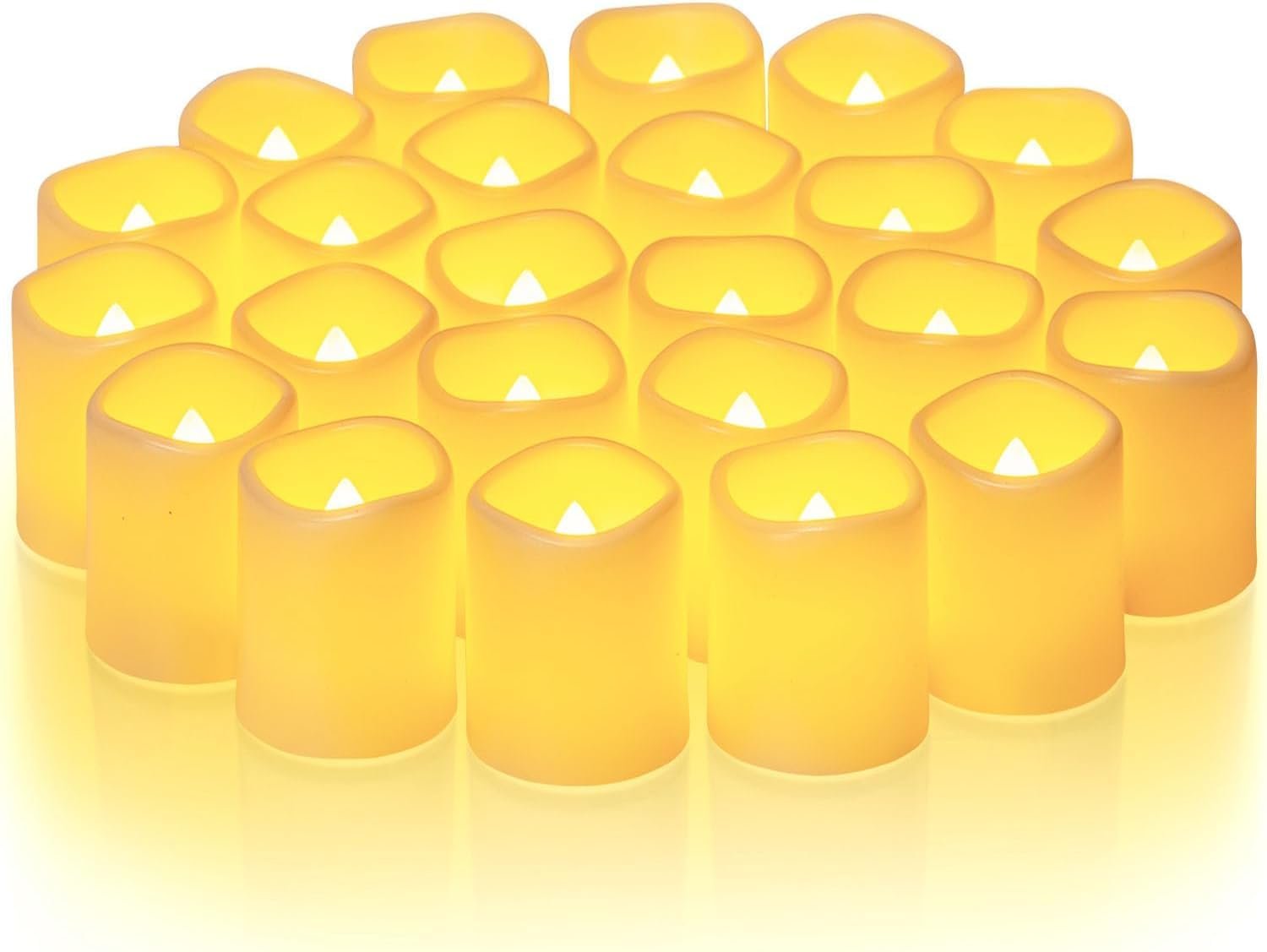 A group of 24 flickering flameless LED votive candles with warm white light, arranged closely together on a white surface.