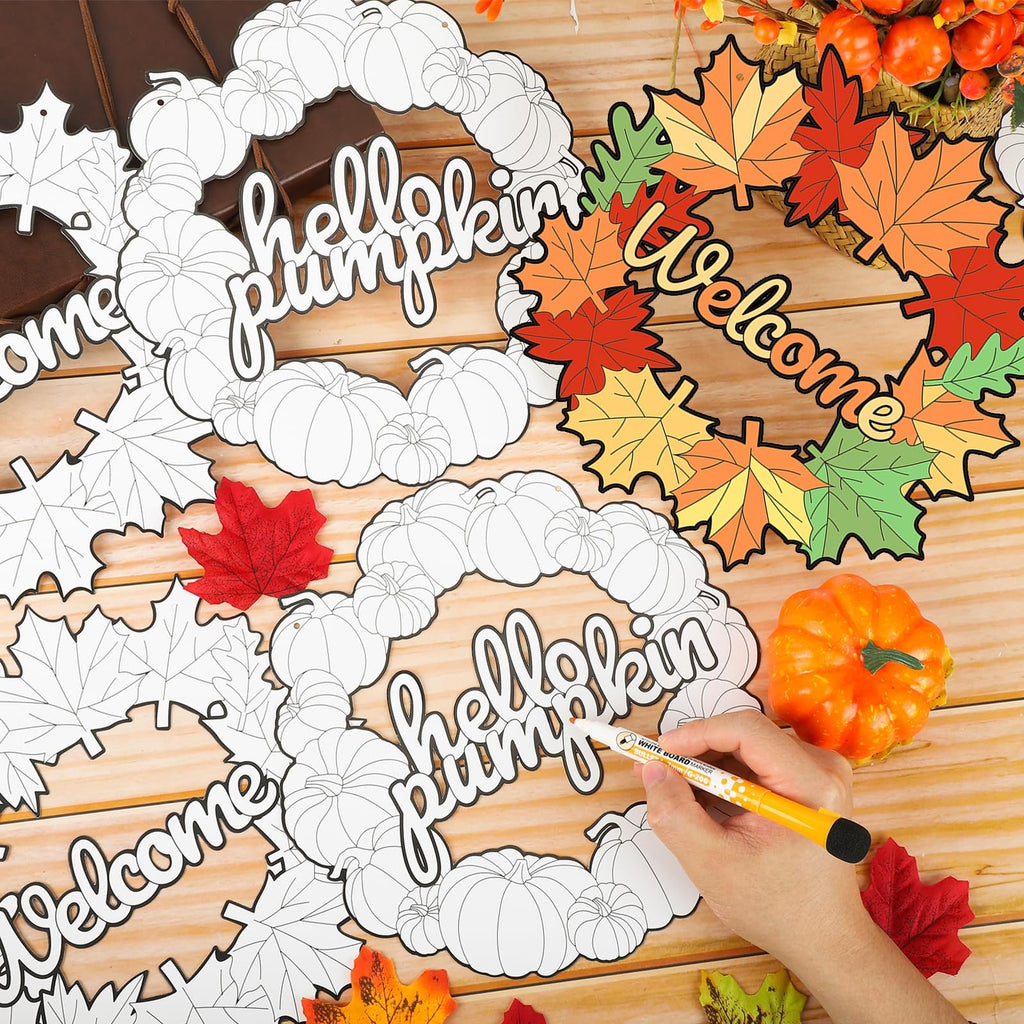Fall wreath craft kits with pumpkins and leaves, one being colored with a marker.