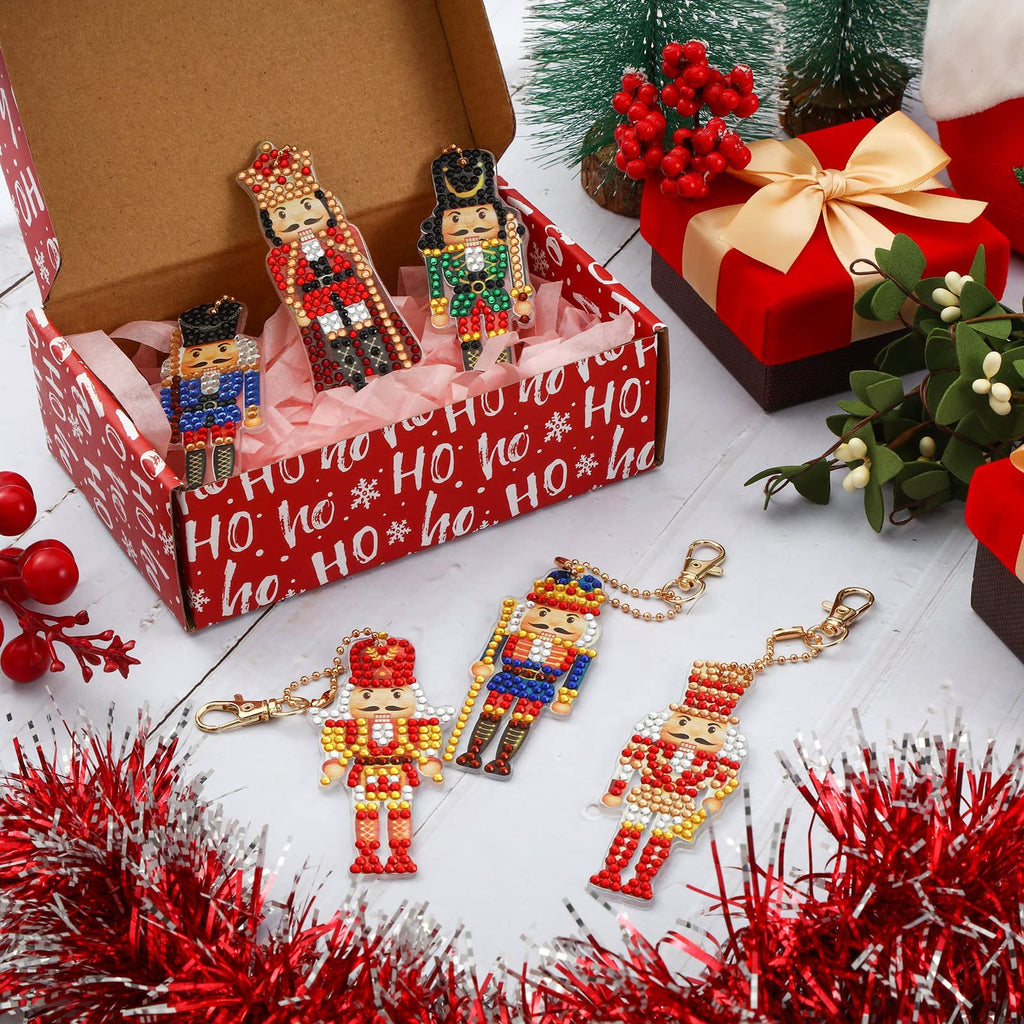 Christmas nutcracker diamond painting keychains displayed with gift boxes and festive decorations.