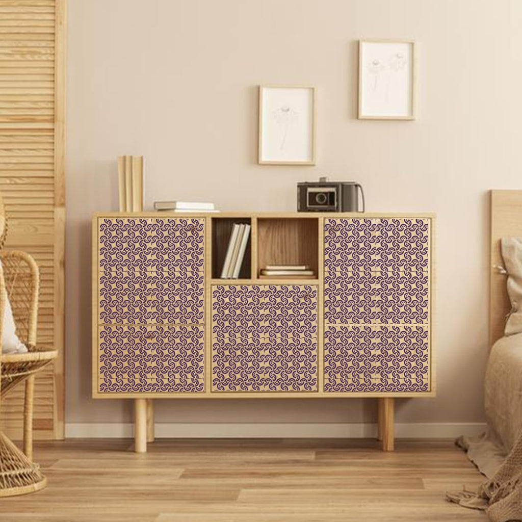 Geometric stencils applied to the doors and drawers of a wooden cabinet in a bedroom setting.