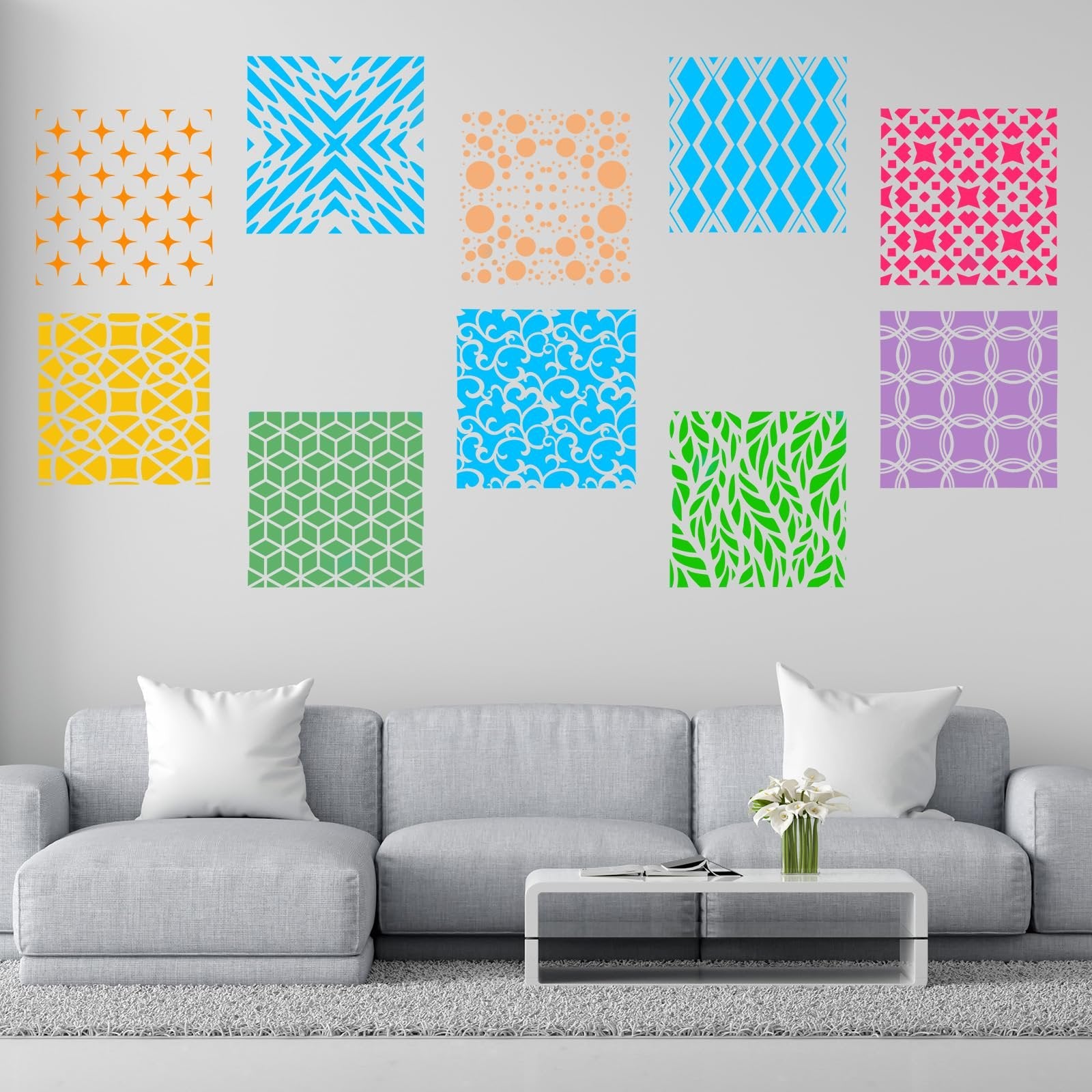 Collection of ten colorful geometric stencils displayed on a wall above a modern gray sectional sofa and coffee table.