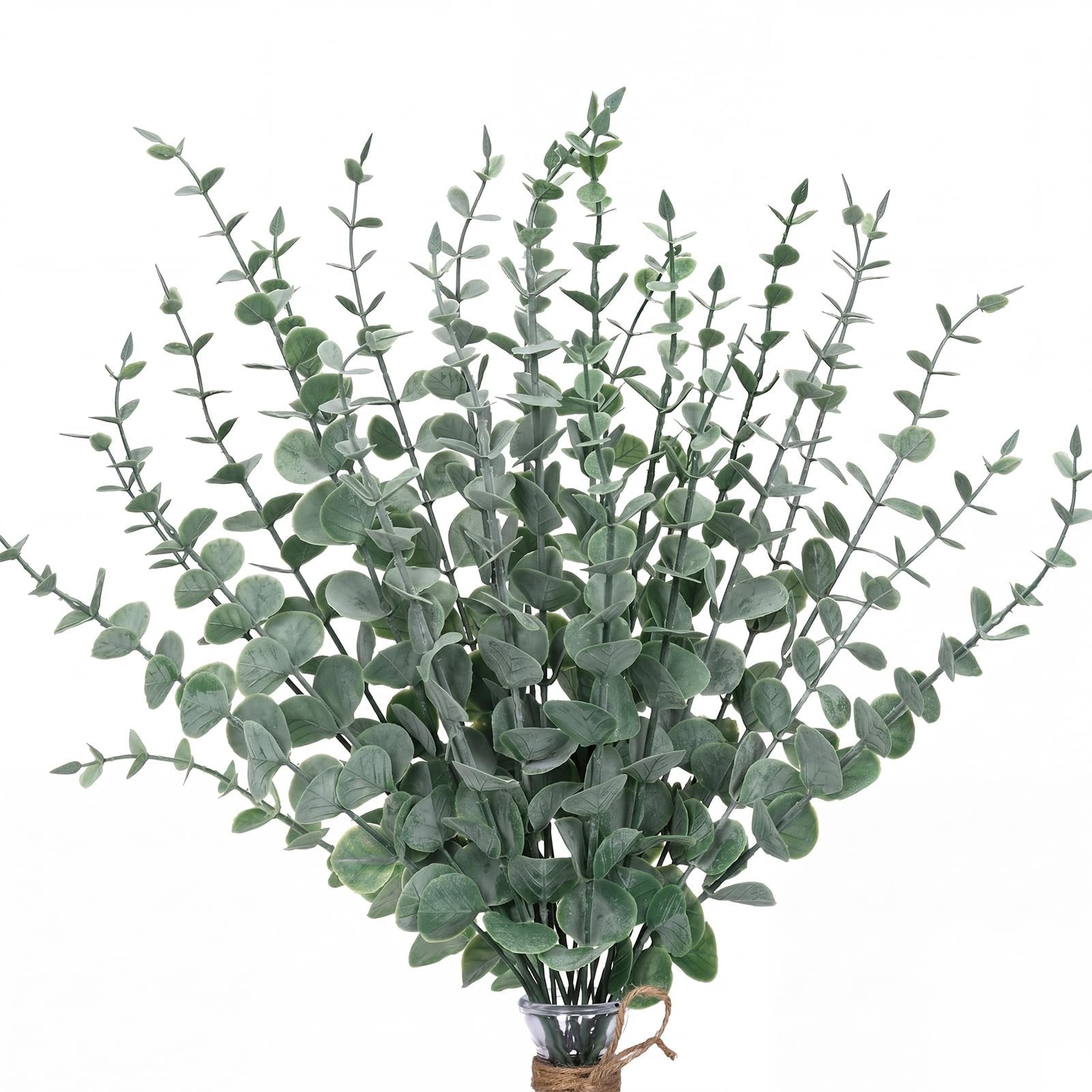 Bunch of artificial eucalyptus stems with frosty gray-green leaves in a glass vase tied with twine