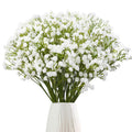 Bunch of white artificial baby's breath flowers in a white vase against a white background