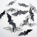 Assortment of black 3D vinyl Halloween bat wall stickers with various cut-out designs like spiderwebs and moons, arranged on a white background.