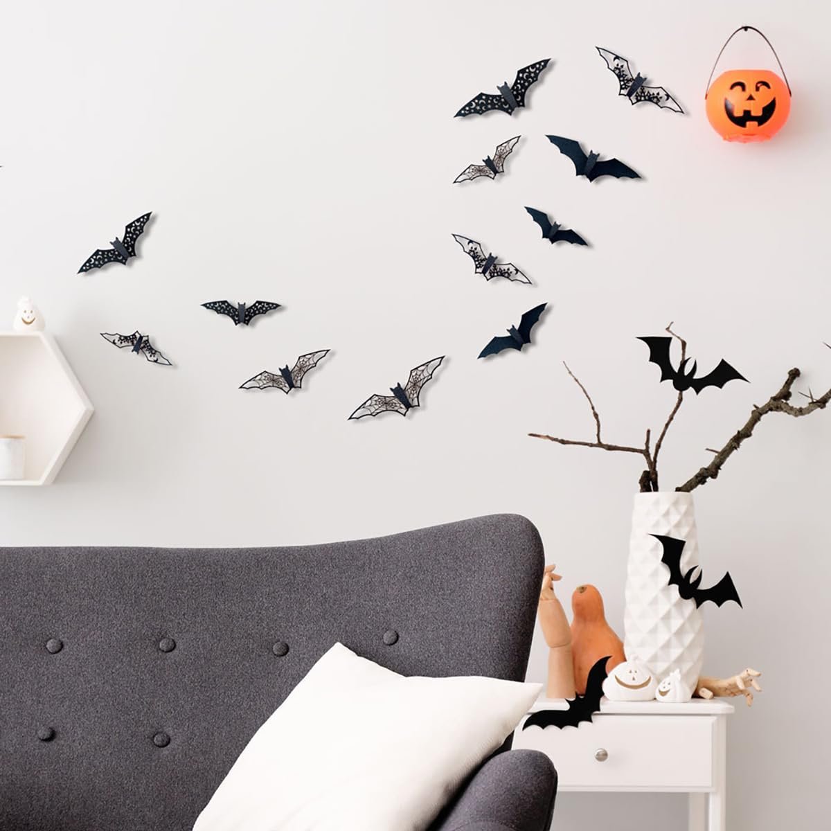 Halloween bat wall stickers in various sizes and designs decorating a wall above a sofa and side table.