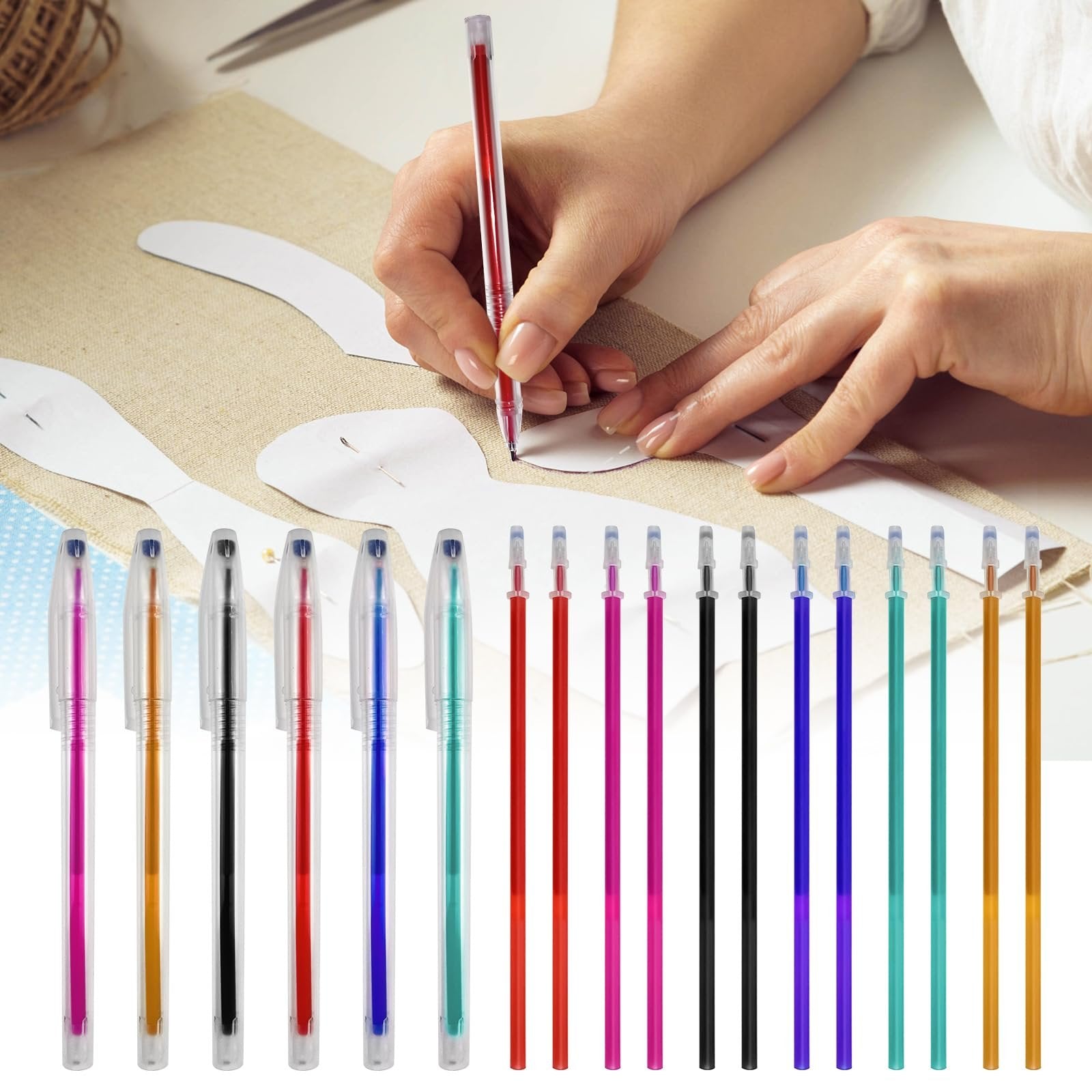 Hands using a red heat erasable fabric pen to trace a pattern on beige fabric, with a line of colorful pens below.