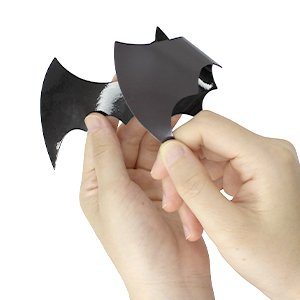 Hands holding a black magnetic bat Halloween decoration against a white background