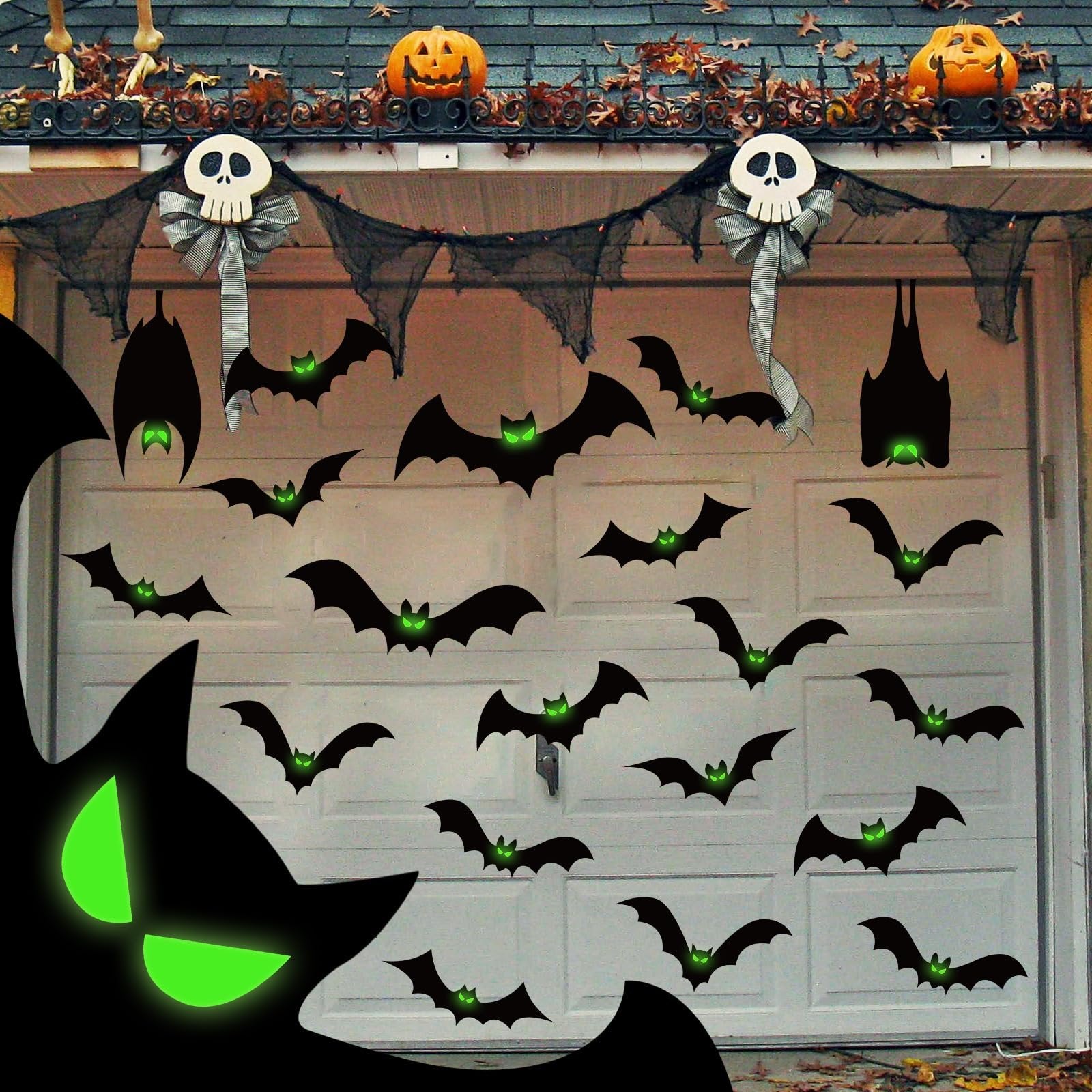 Halloween garage door decorations with black bats and glowing green eyes, plus skull and pumpkin accents.