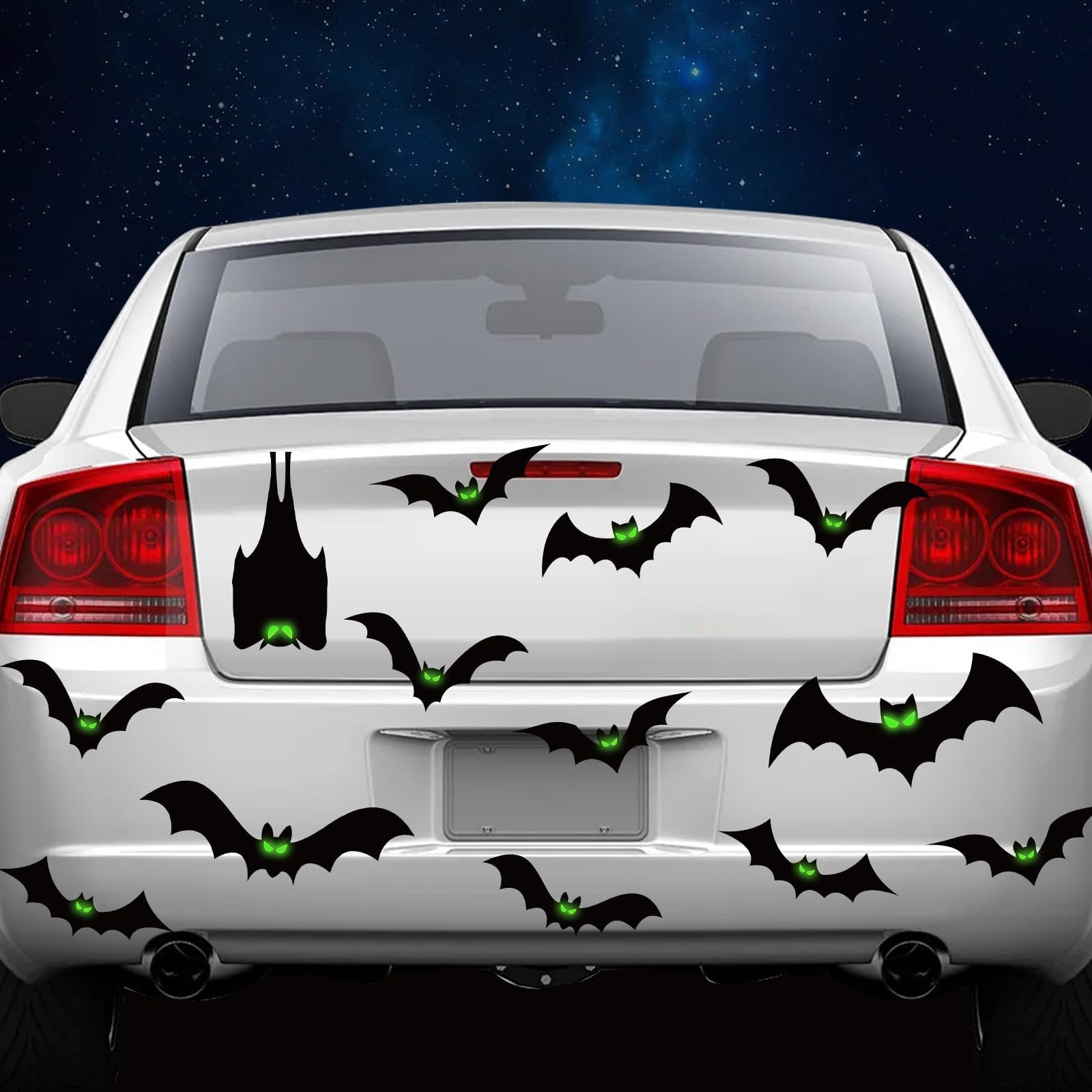 White car trunk decorated with black magnetic bat Halloween decals with glowing green eyes against a starry night sky background.