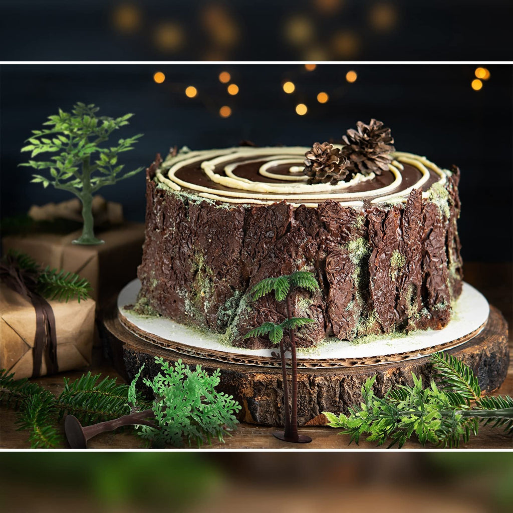Chocolate cake decorated as a tree stump with miniature trees and pine cones, set on a wooden stand with festive lights in the background.