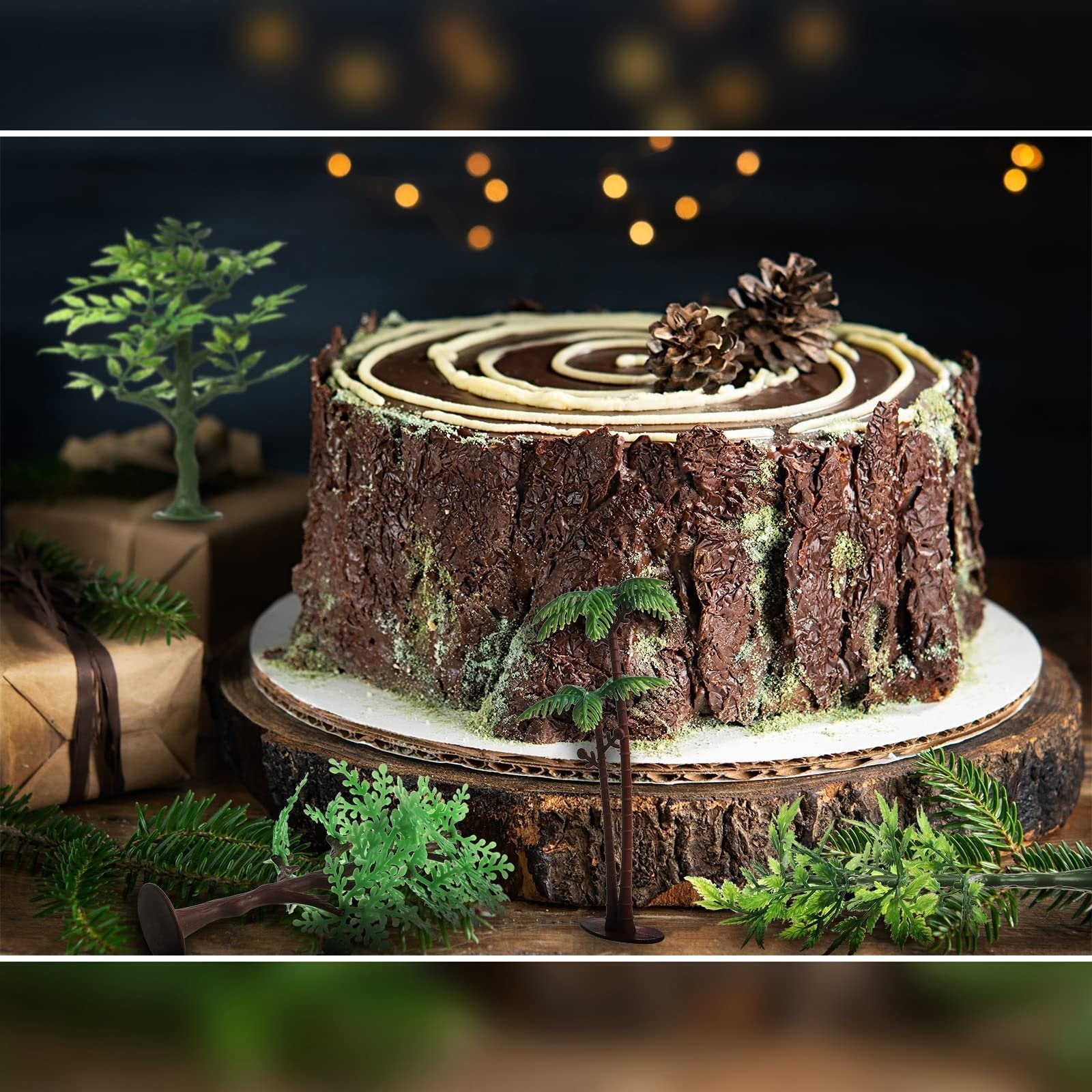 Chocolate cake decorated as a tree stump with miniature trees and pine cones, set on a wooden stand with festive lights in the background.